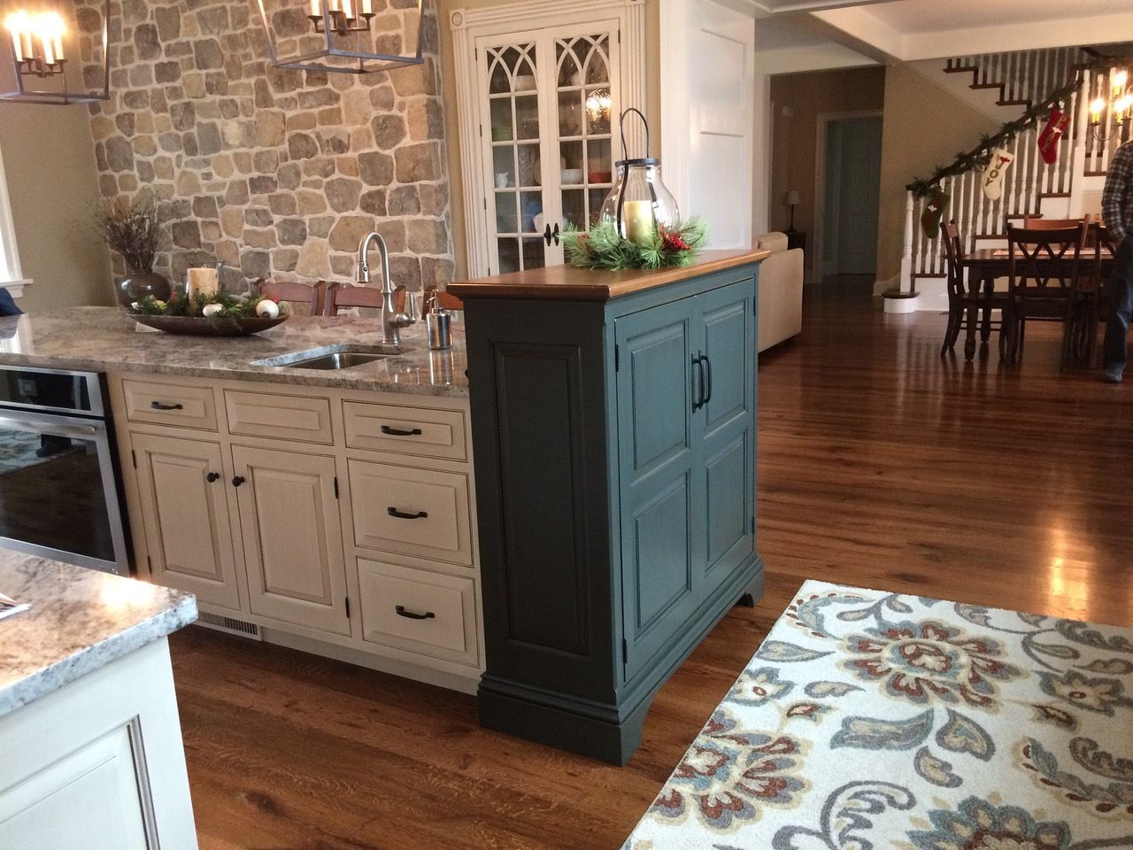 A kitchen with white cabinets has a newly refinished hardwood floor