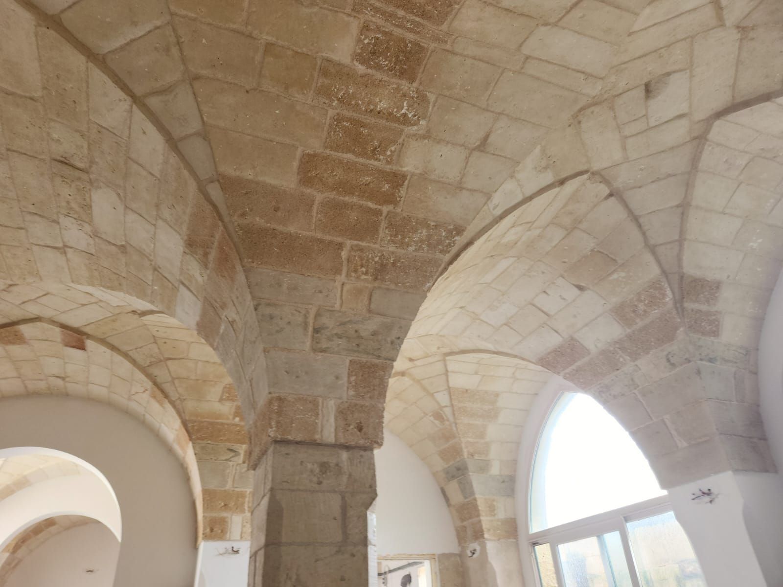Soffitto a volta in pietra con finestre ad arco in un luminoso interno storico