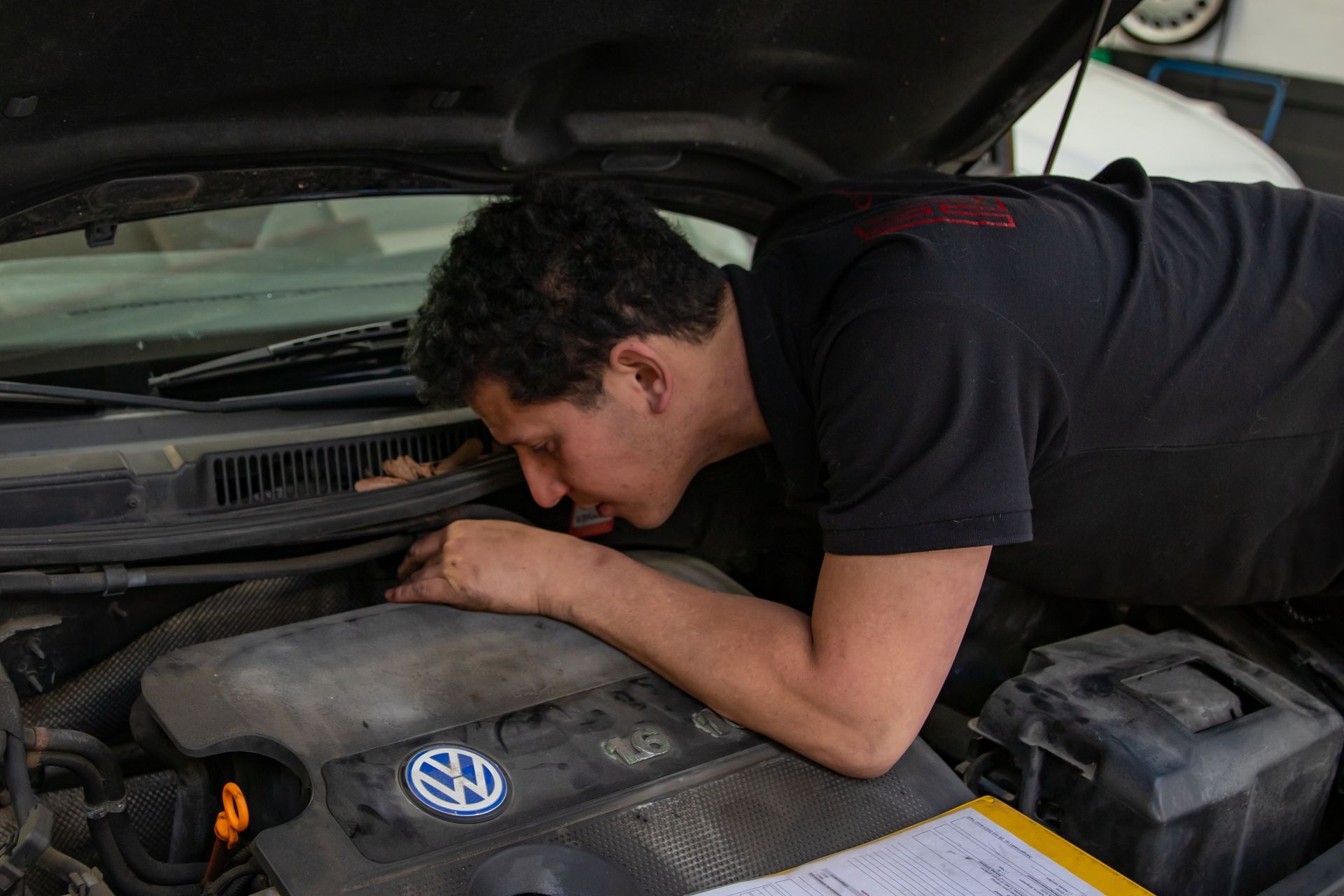 Monteur van Autobedrijf Cieraad controleert een auto onder de motorkap