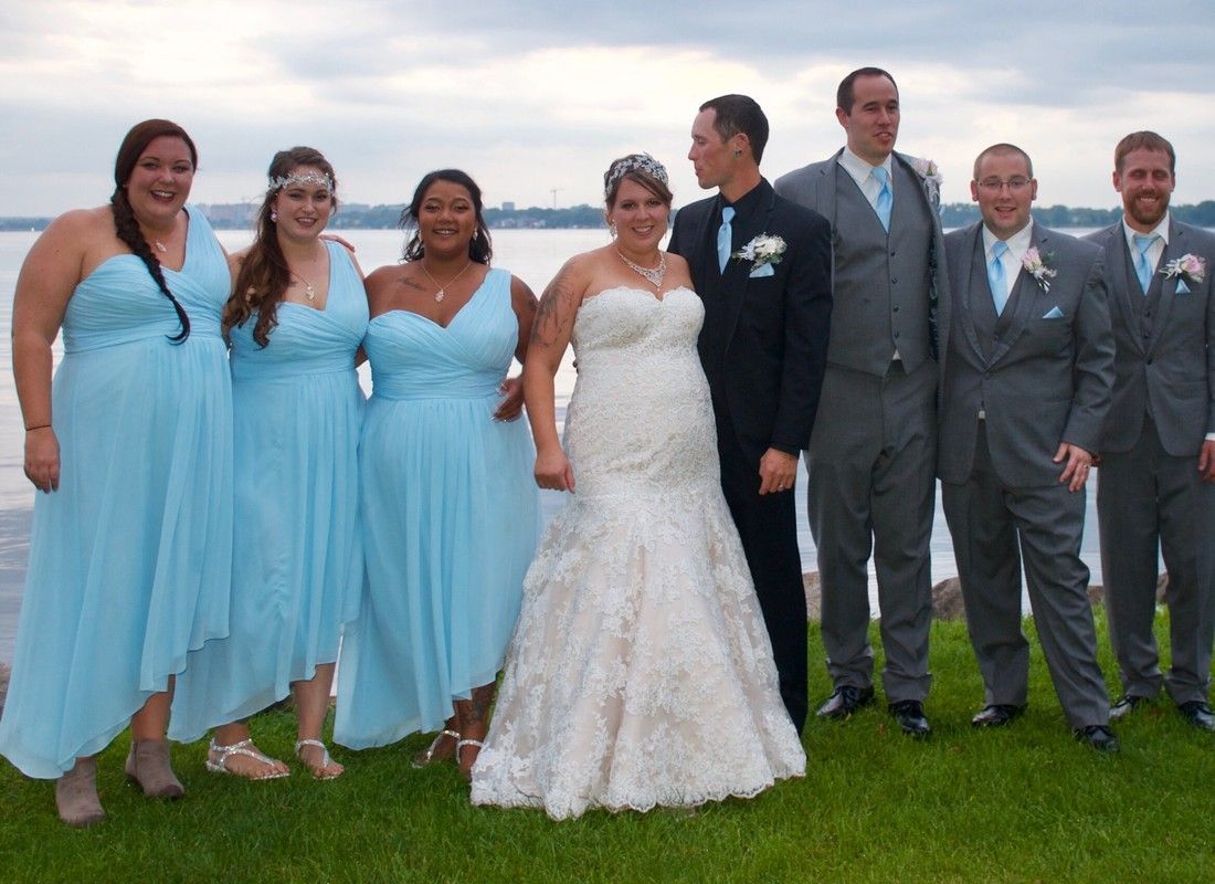 Wedding party posing outdoors on grass