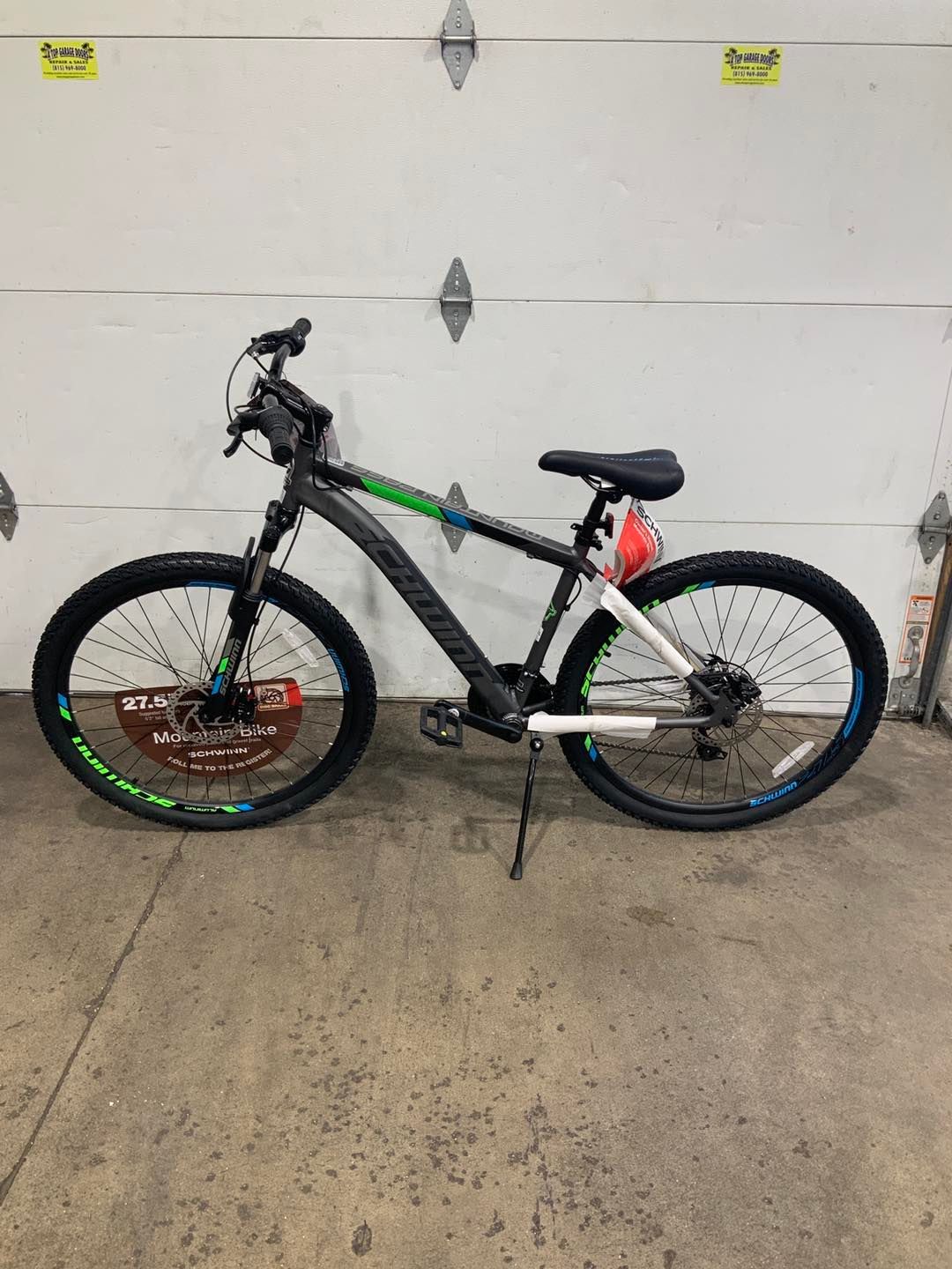 A bicycle is parked in front of a garage door.