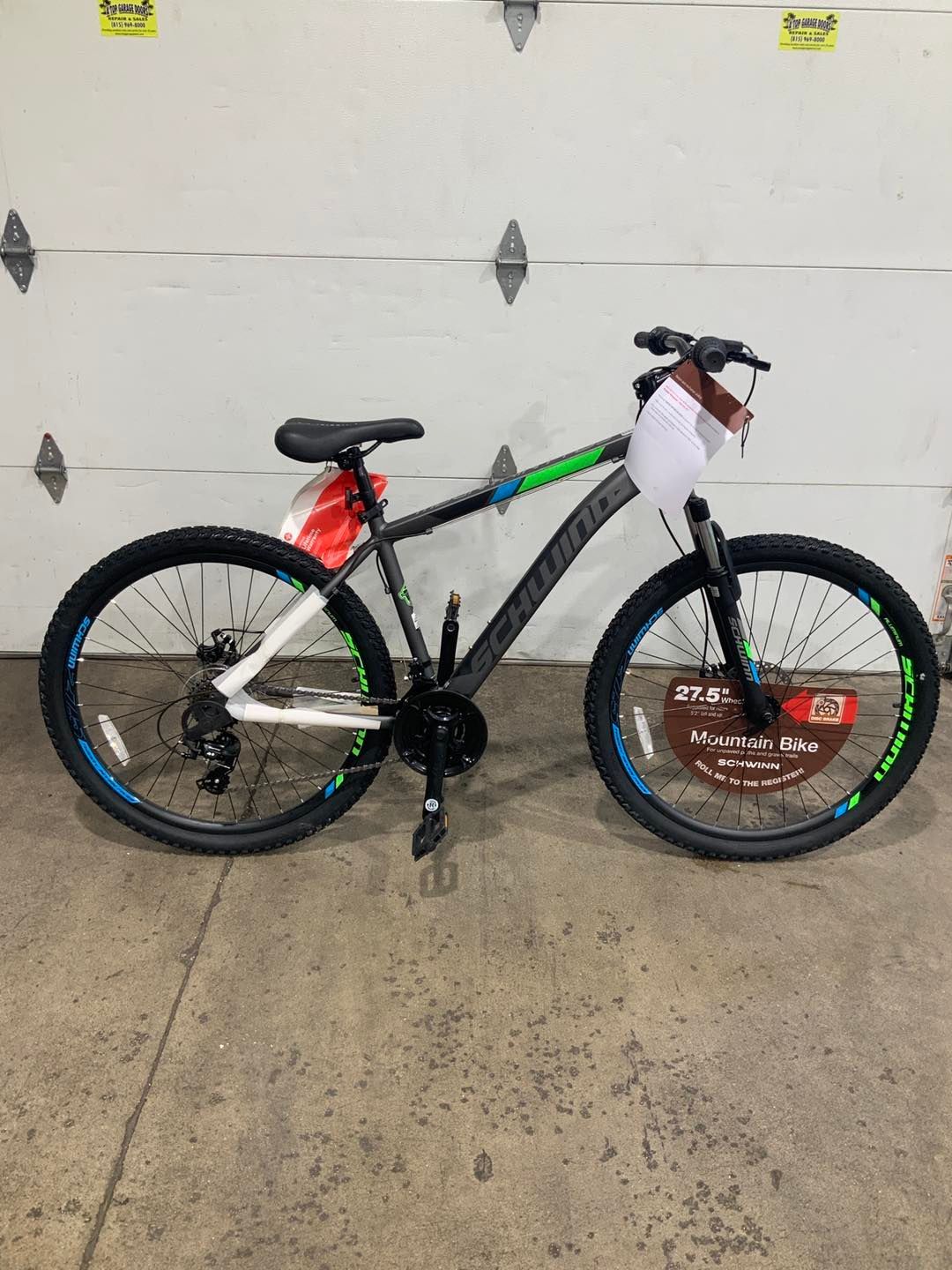A bicycle is parked in front of a garage door.