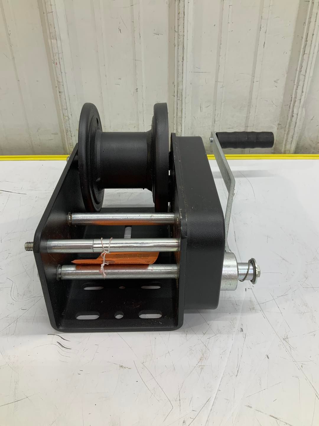 A black winch is sitting on top of a white table.