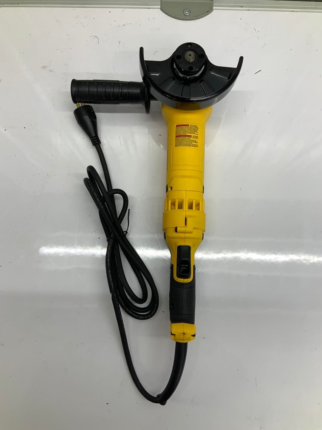 A yellow and black grinder is sitting on a white surface.