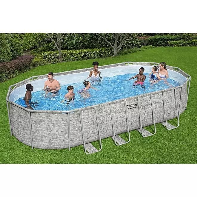 A group of people are swimming in an oval swimming pool.