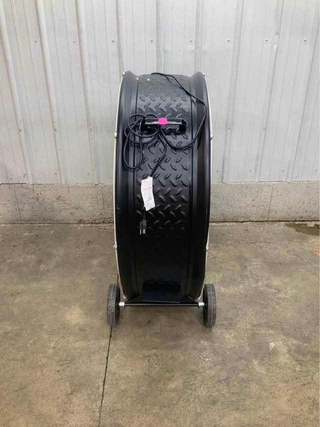 A black tire with wheels is sitting on the ground in front of a building.