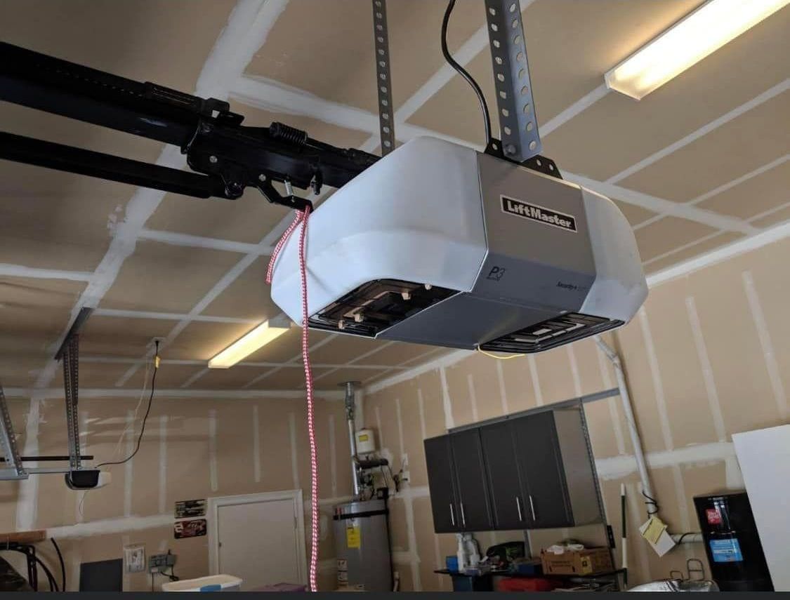 A garage door opener is hanging from the ceiling in a garage.