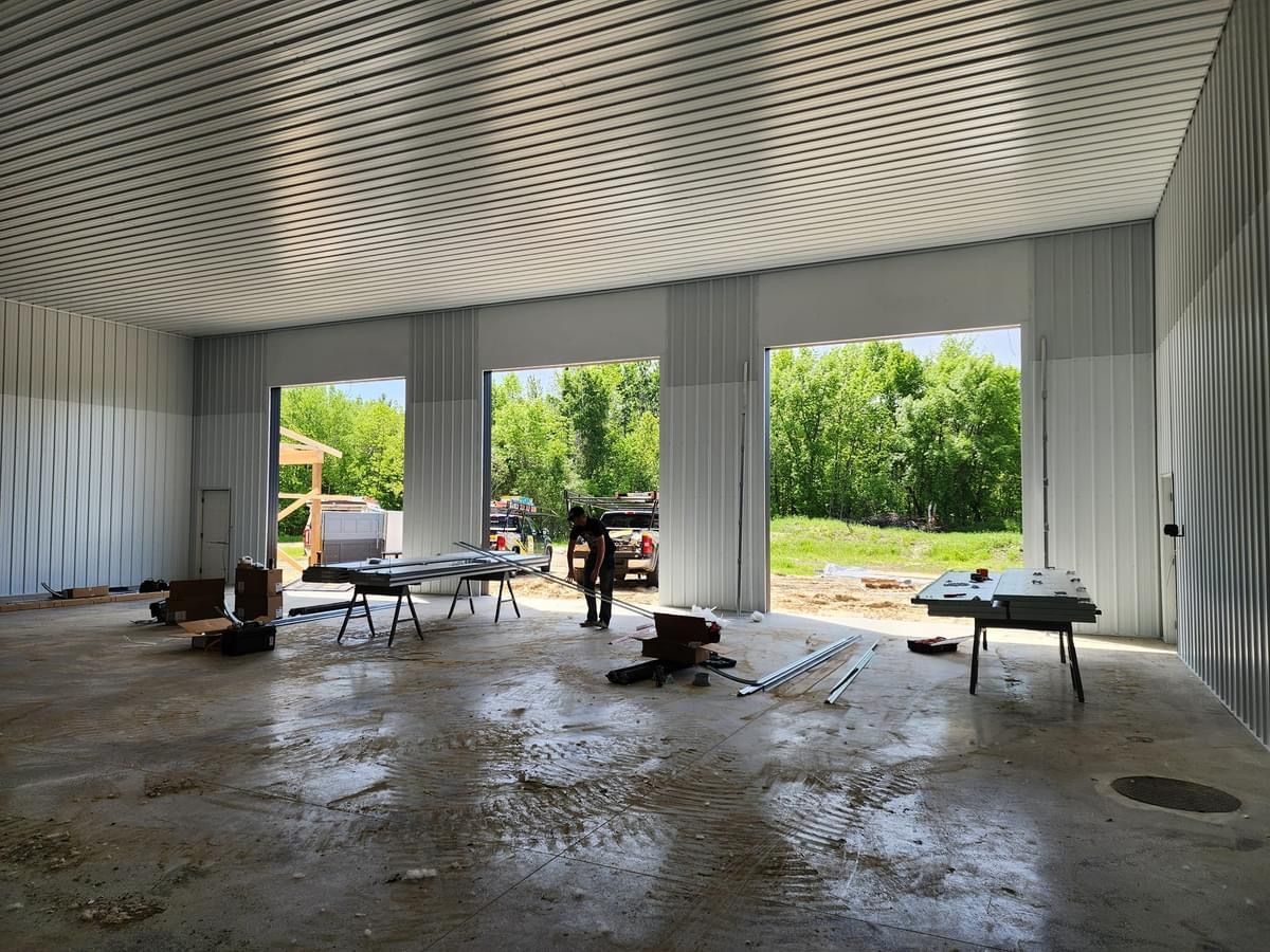 A large empty building with a lot of windows and a table in the middle of it.