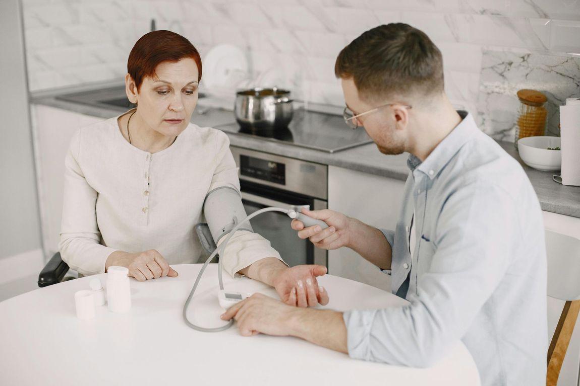 Medical professional measuring a patient’s blood pressure in a bright clinic room