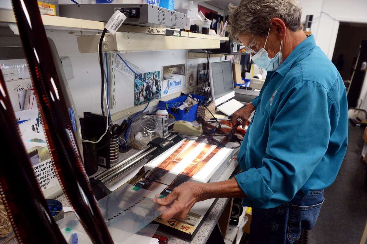Photography lab technician Dory Neilson works in her modern photography darkroom at Milford Photo.