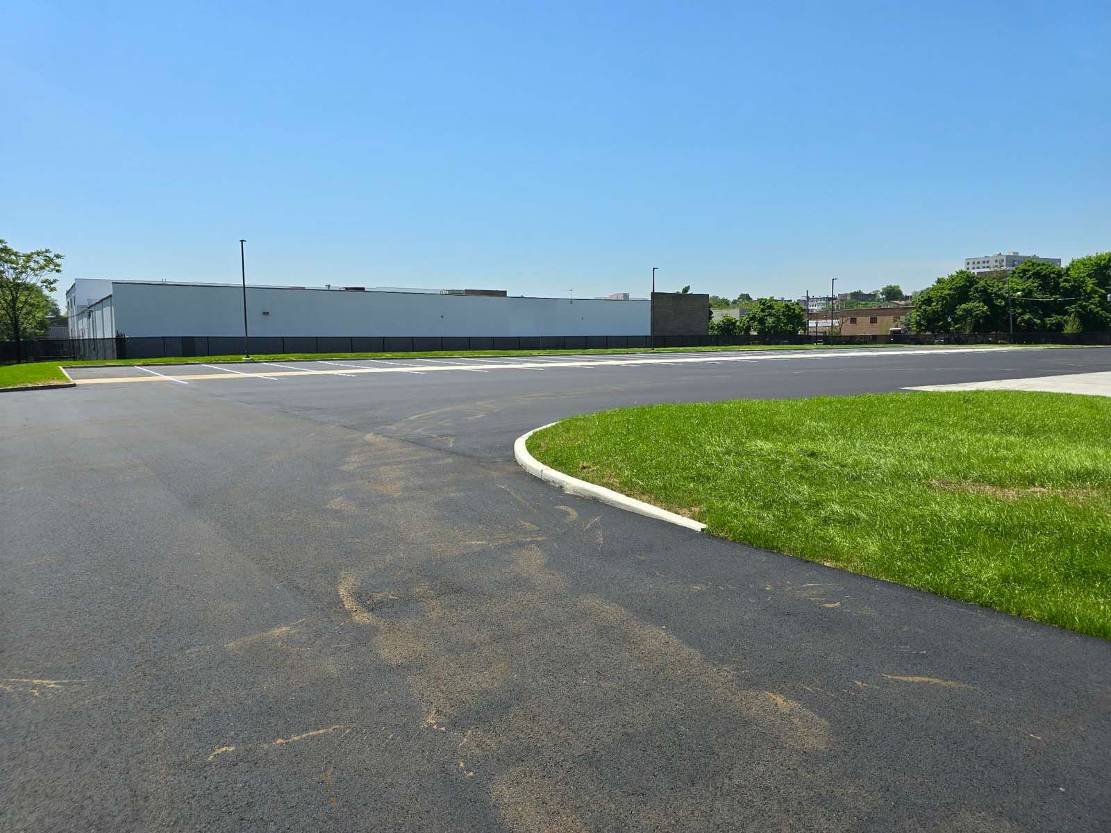 An empty parking lot with a white building in the background
