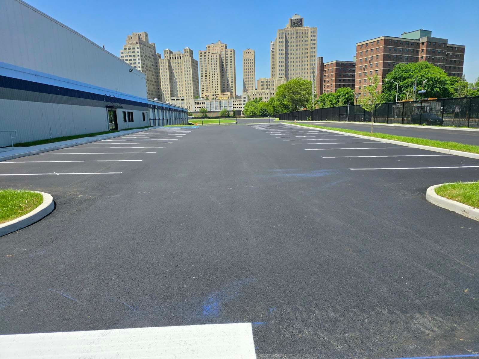 An empty parking lot with a city in the background