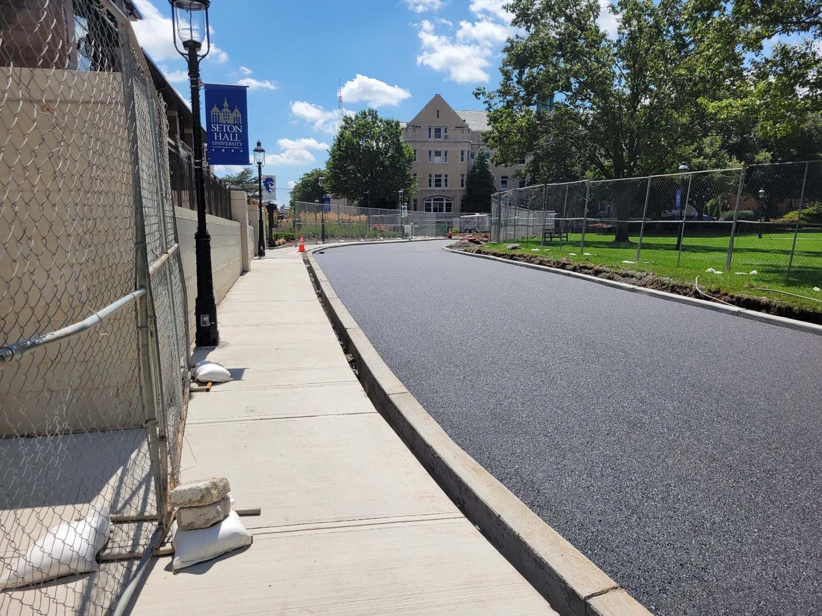 A sidewalk with a chain link fence and a sign that says ' king ' on it