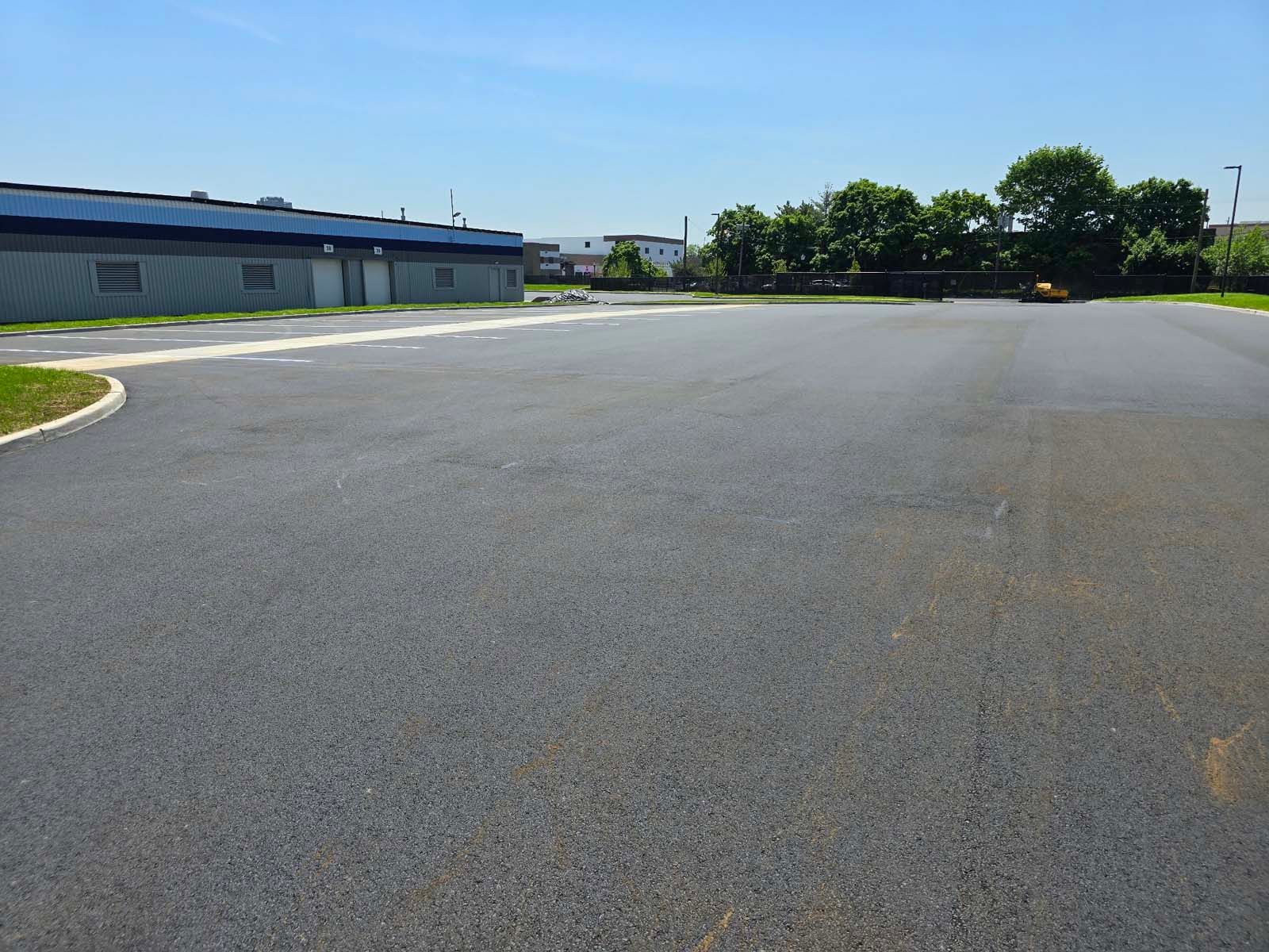 An empty parking lot with a building in the background