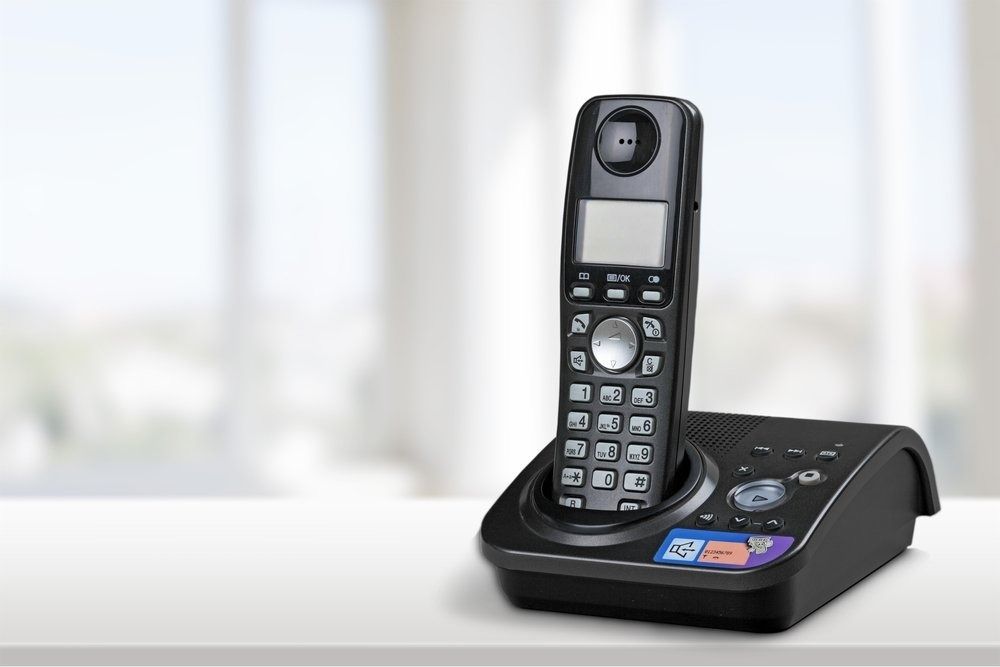 A Cordless Phone is Sitting on Top of a White Table — Central Coast Batteries In Long Jetty, NSW
