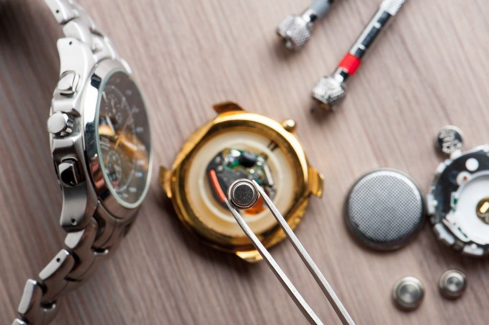 A Watch is Being Repaired on a Wooden Table — Central Coast Batteries In Long Jetty, NSW