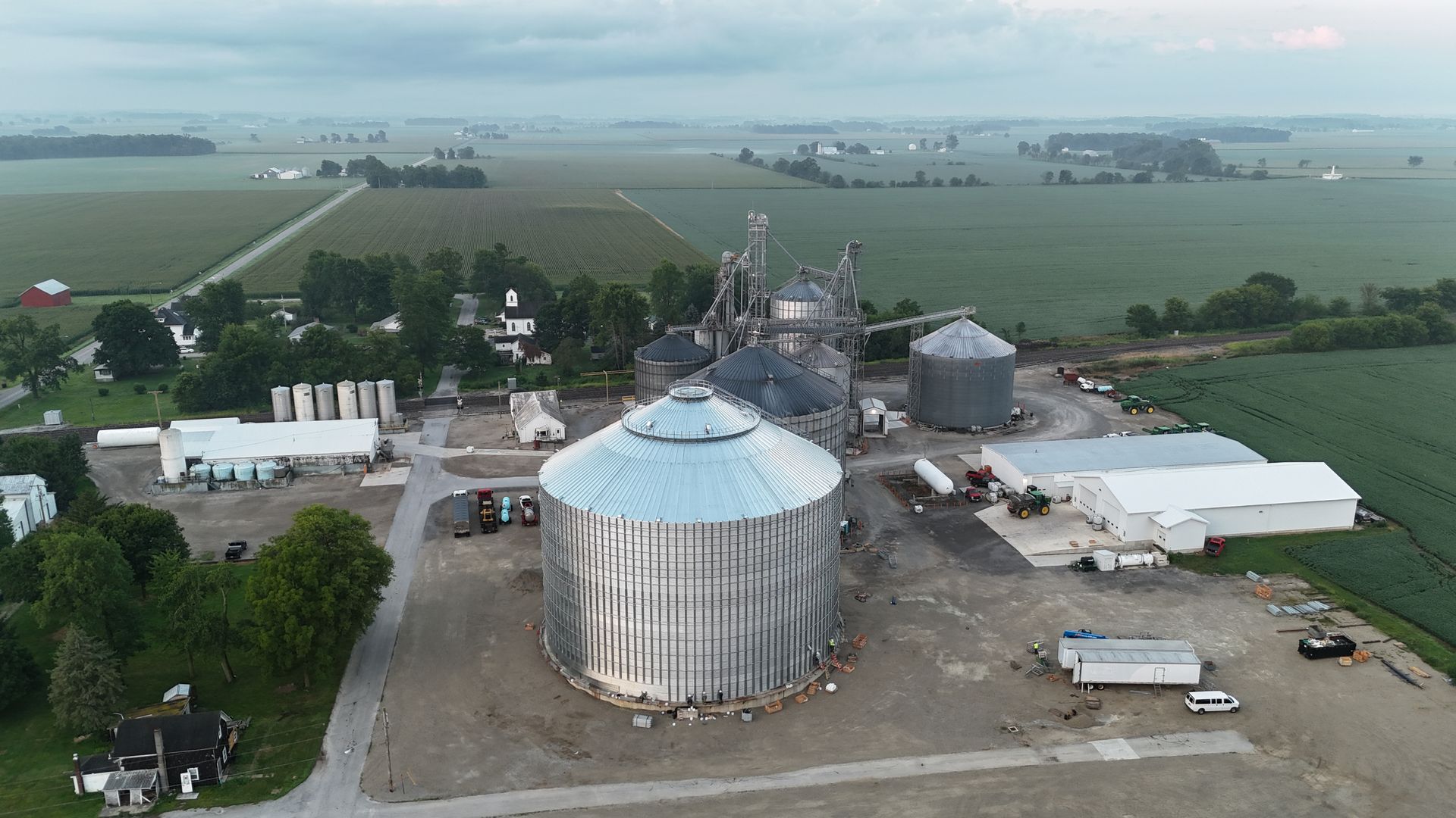 Aerial view of a farm grain silo complex with fields stretching into the distance.