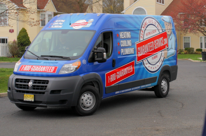Blue promotional van parked on a street, covered with red and white advertising text.