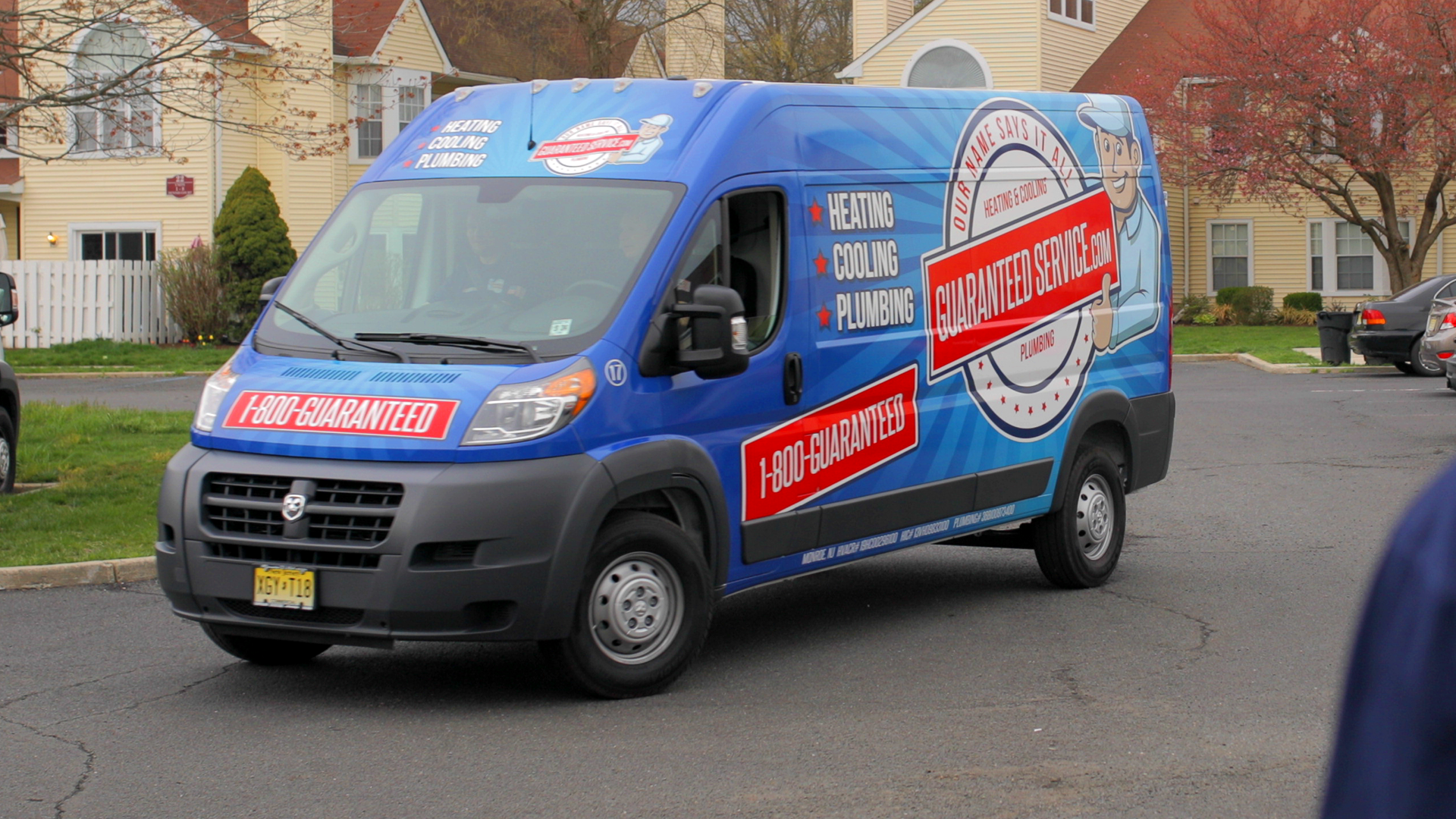 A blue van is parked in front of a house