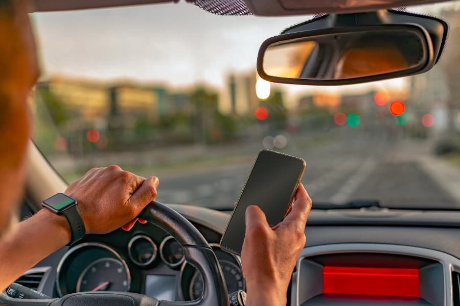 Blurred close-up of a man texting and driving. 