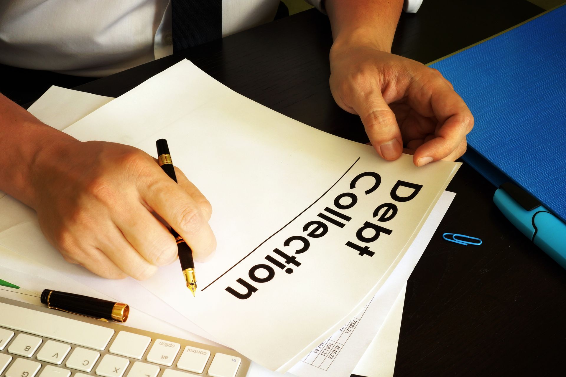 Manager at a debt collection agency holding documents in a modern office setting.