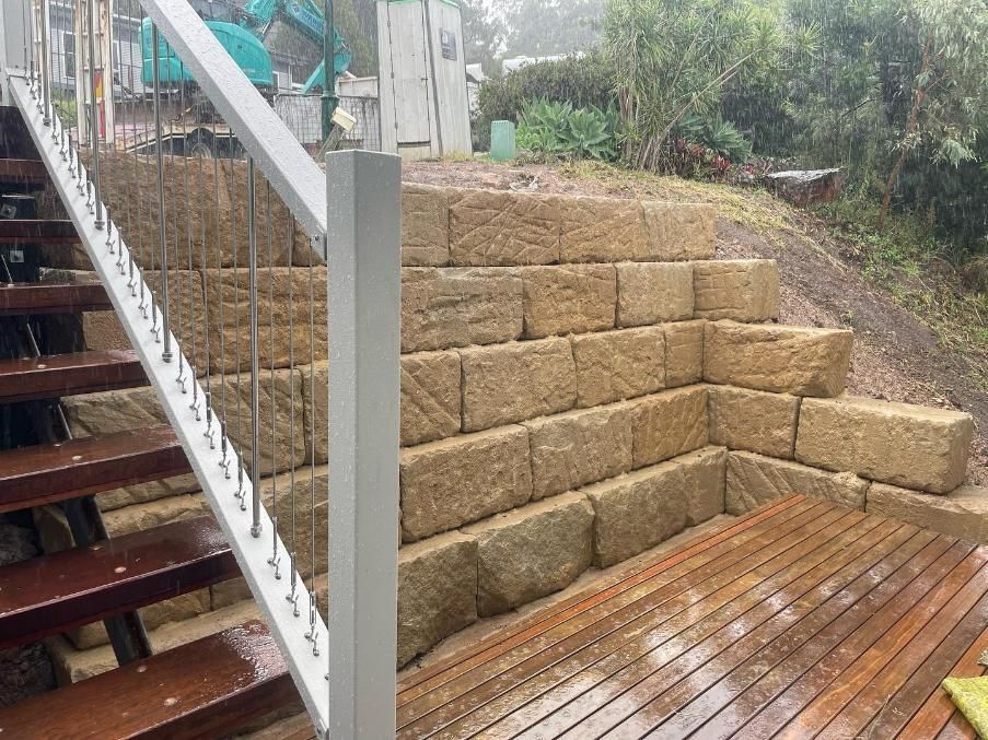 A Wooden Deck with Stairs Leading up To a Stone Wall — Webster Rock Walls In Gympie, QLD