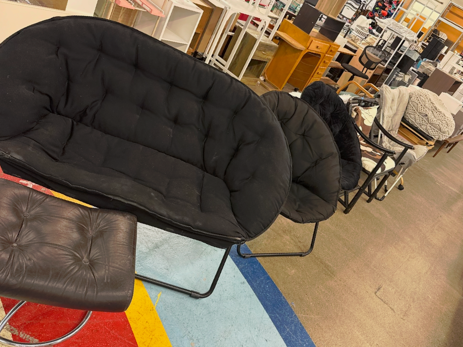 Black cushioned chair and ottoman in a furniture store display area