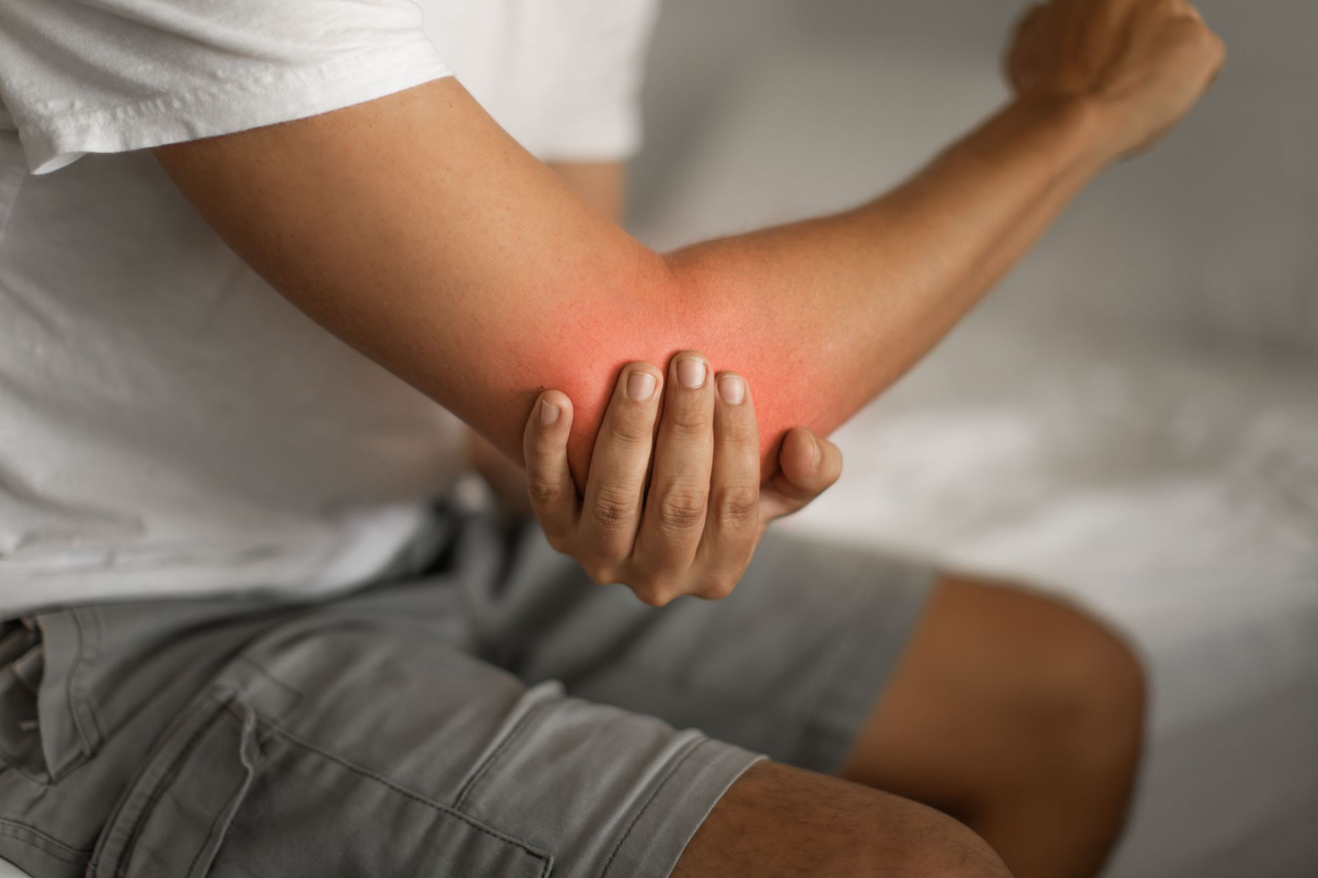 Chiropractor treating tennis elbow pain with remedial massage in Adelaide