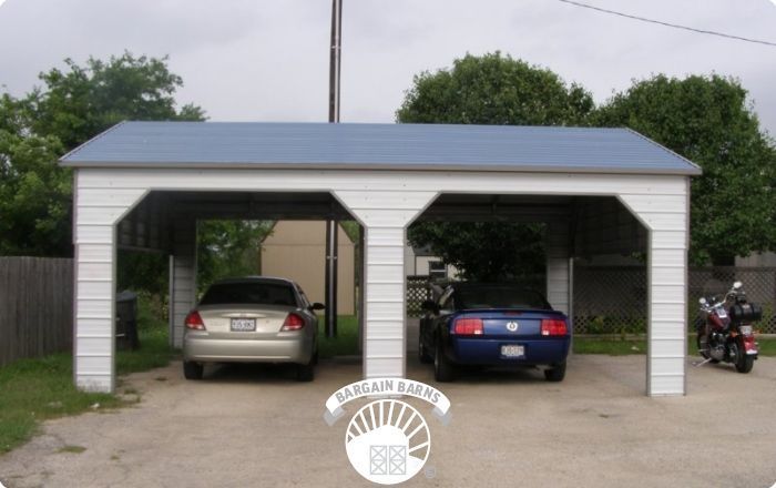 Two cars are parked under a carport with the word garage on it