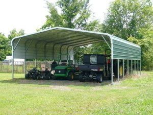 A couple of vehicles are parked under a carport.