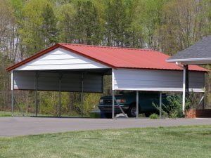 A car is parked under a carport with a red roof.