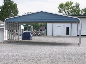 A blue and white carport with a white building in the background