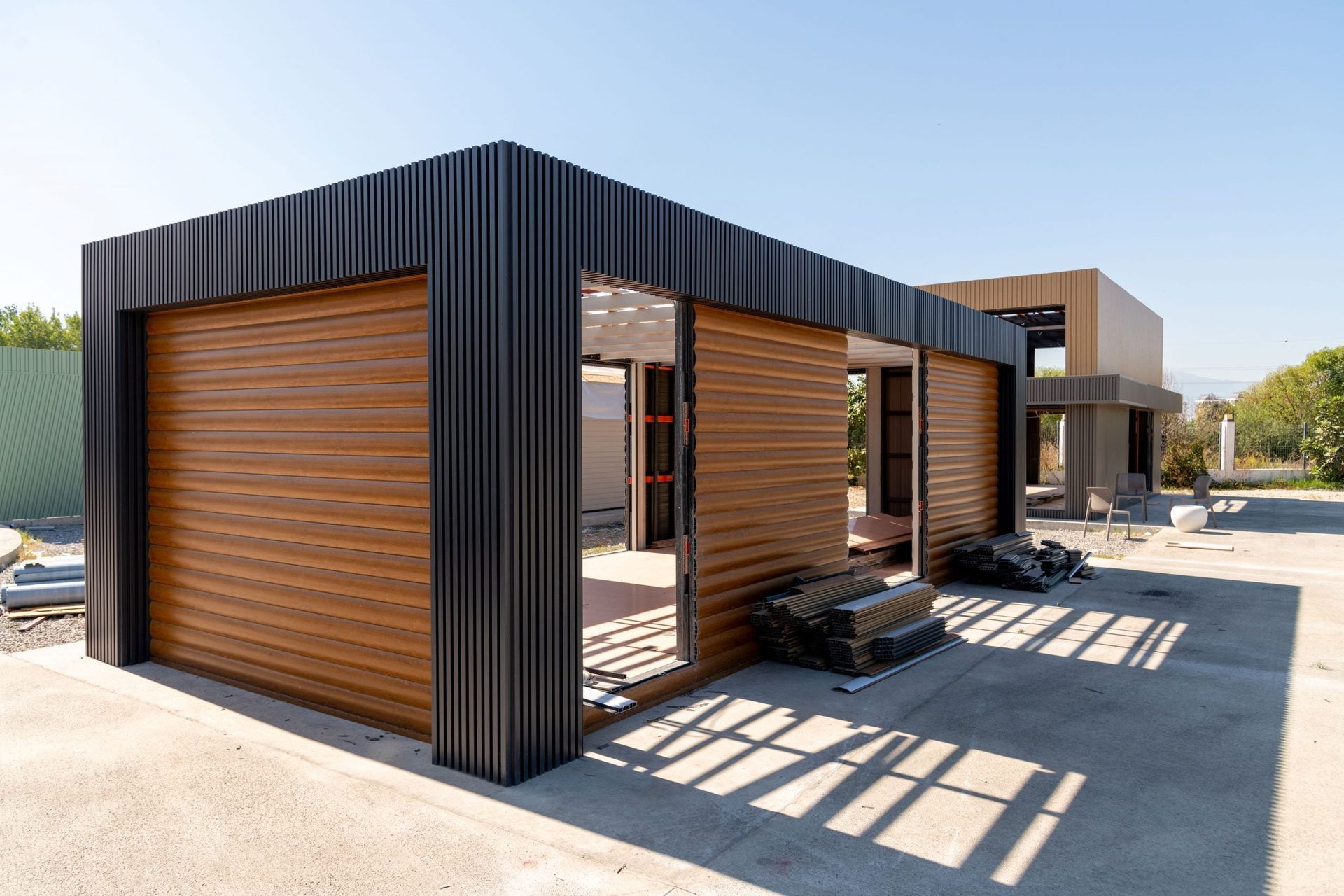 A house is being built with wooden walls and a black roof.