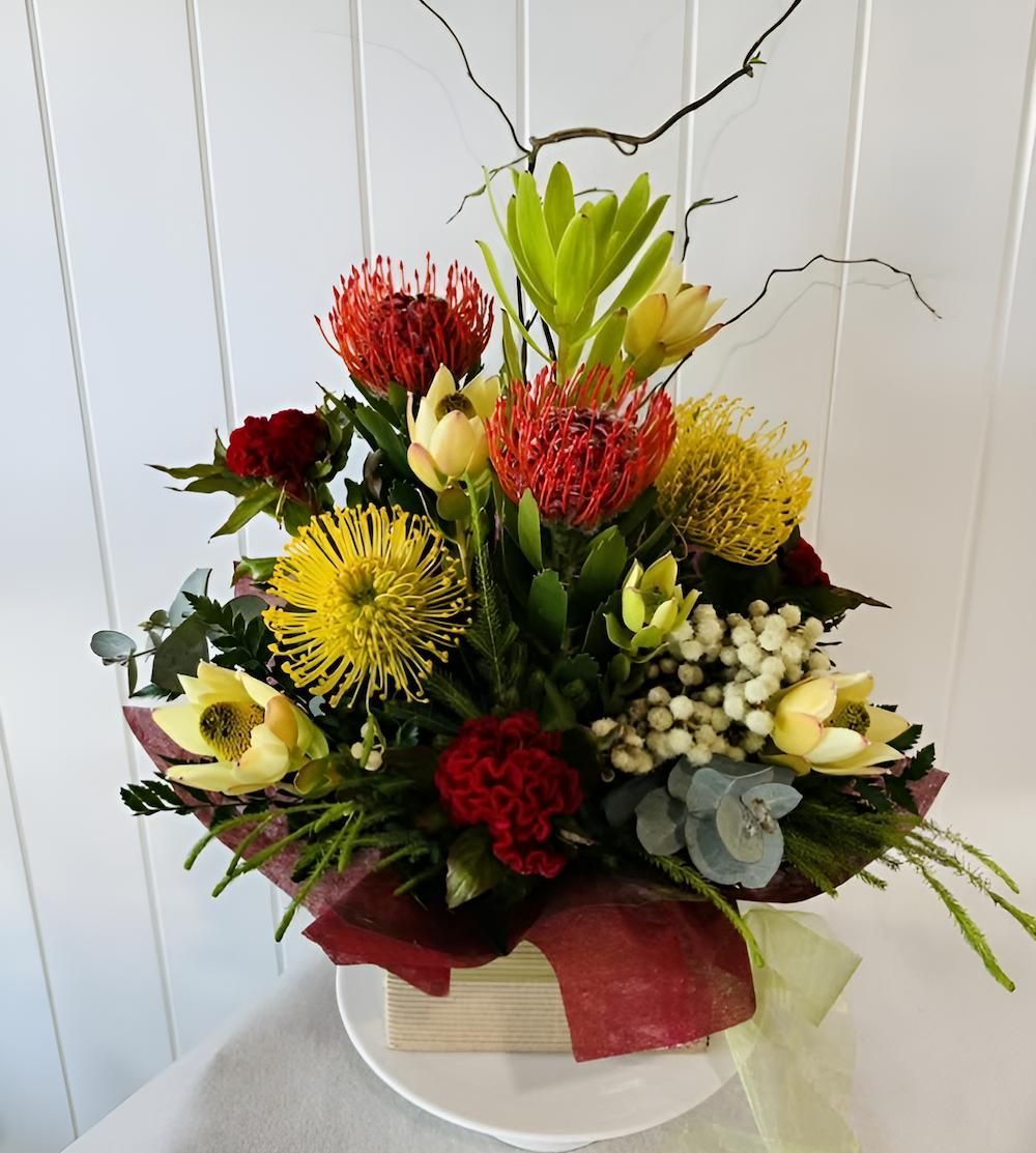 A Bouquet of Flowers in a Wooden Box on a Table — Bundaberg House of Flowers In Elliot Heads, QLD
