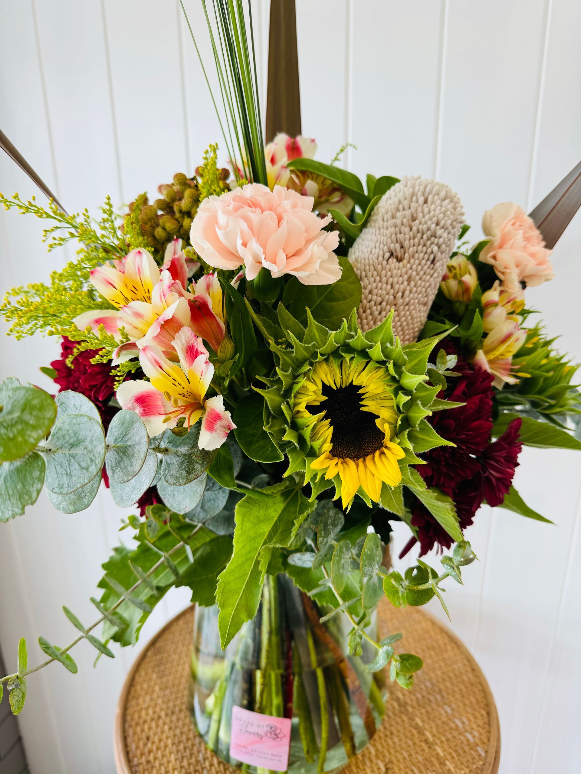 A Vase Filled With Flowers is Sitting on a Table — Bundaberg House of Flowers in Bundaberg West, QLD