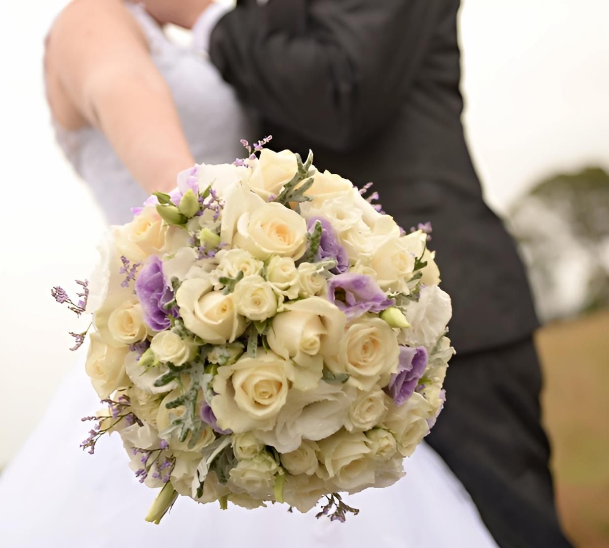 A Bride and Groom Are Kissing and the Bride is Holding a Bouquet of Flowers — Bundaberg House of Flowers In Elliot Heads, QLD