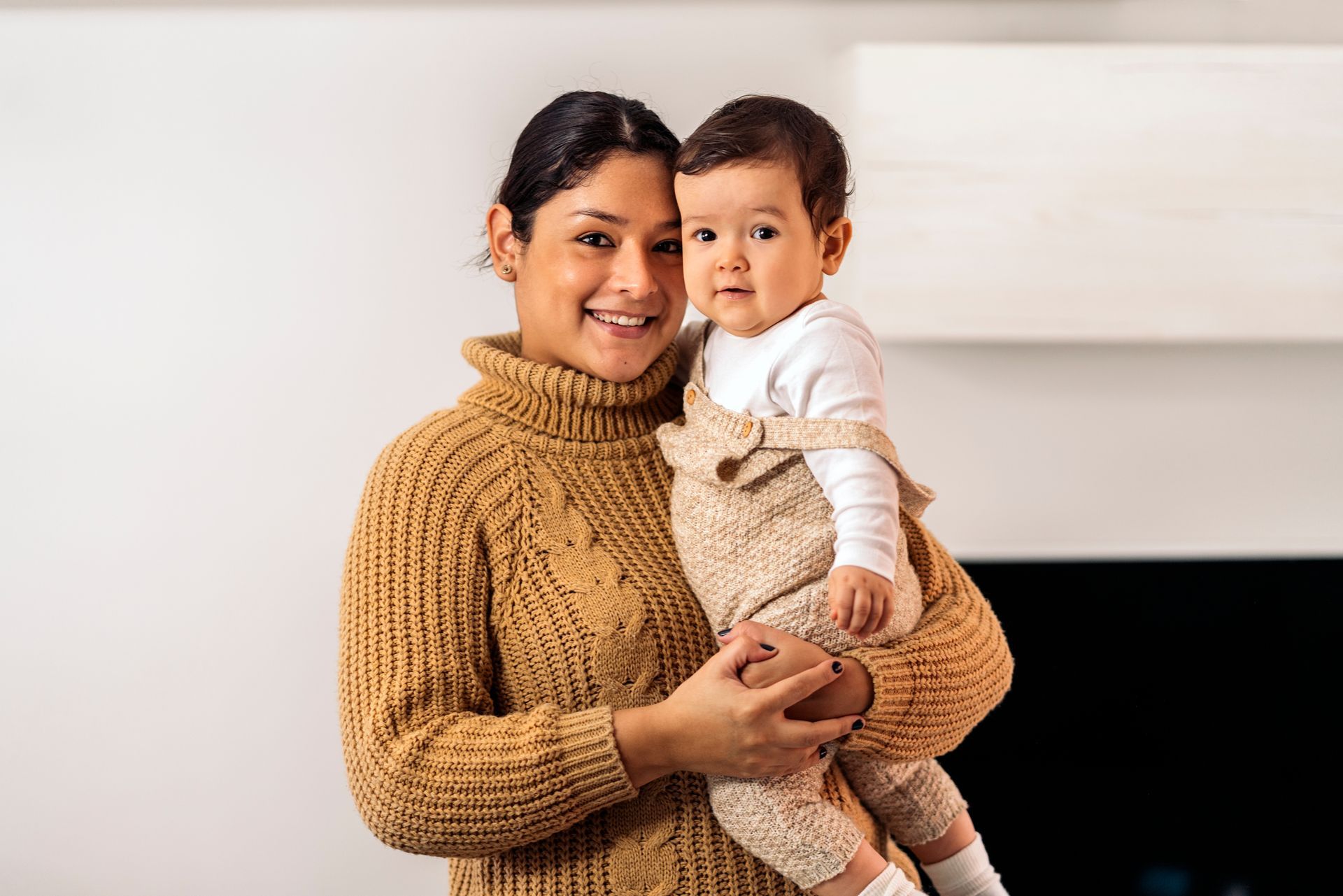 A woman is holding a baby in her arms.