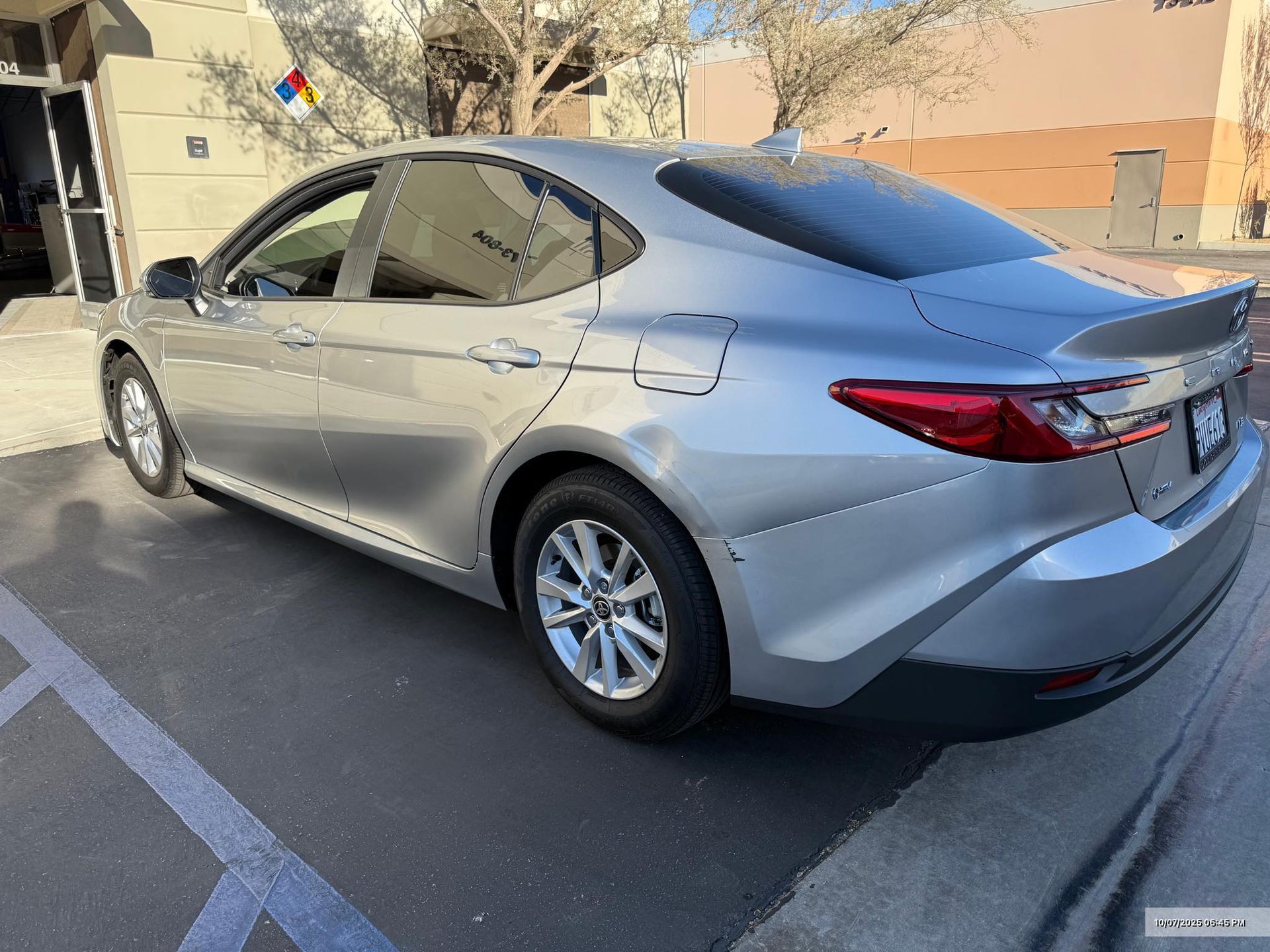 Silver sedan parked outside, sunny day.