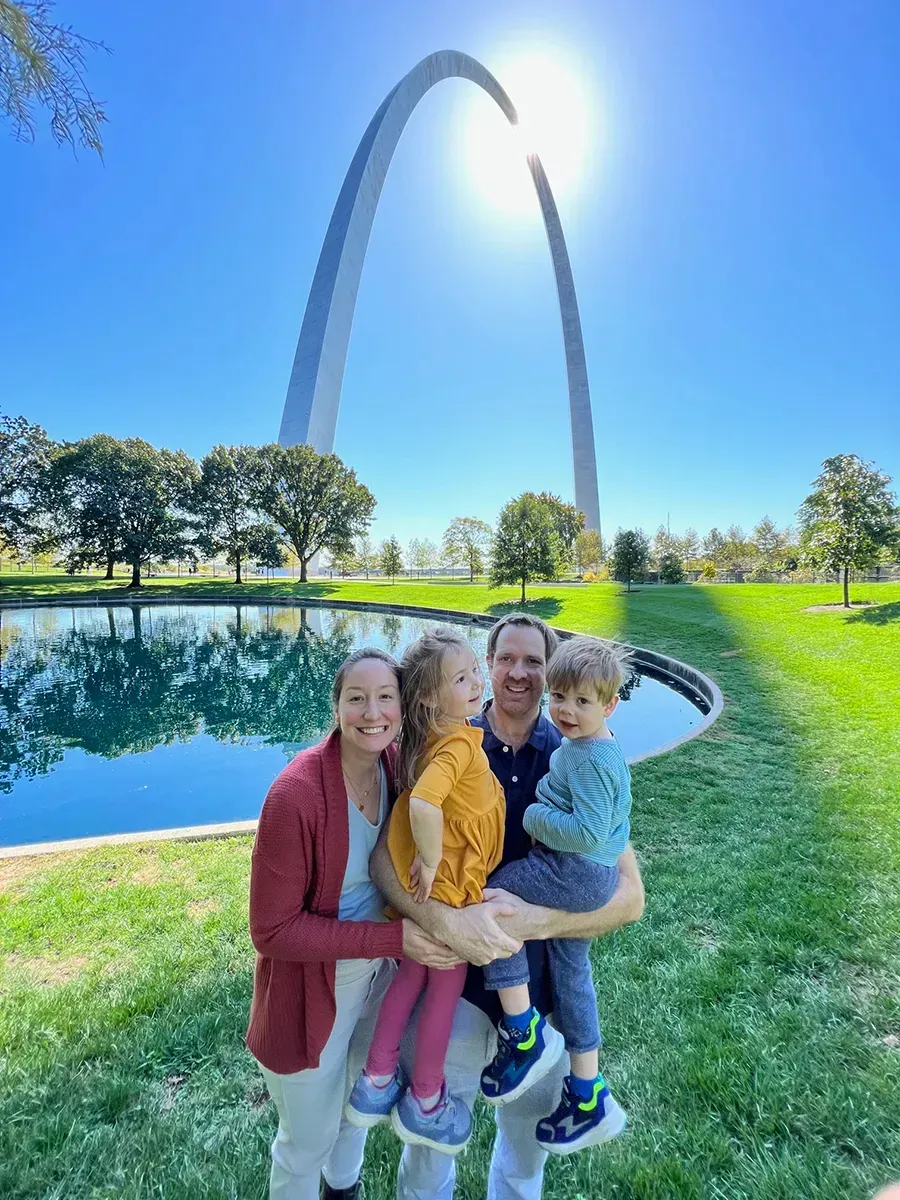 The family of Attorney Andrew Smith is posing for a picture in front of the gateway arch.