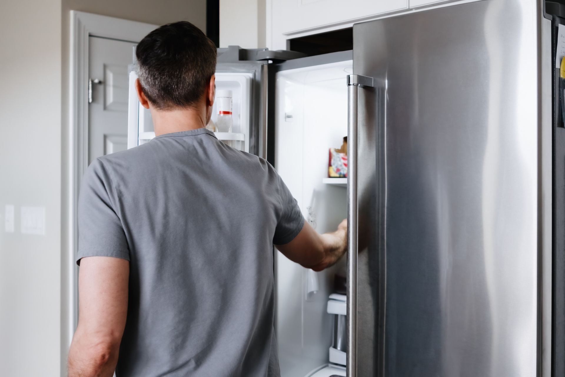 Man Fixing Refrigerator — Corona, CA — Tru-Way Appliance Parts & Service Man Fixing Refrigerator — Corona, CA — Tru-Way Appliance Parts & Service