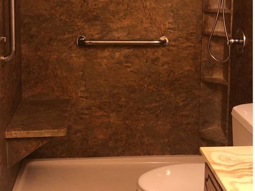 a bathroom with a tub , toilet , sink and shower .