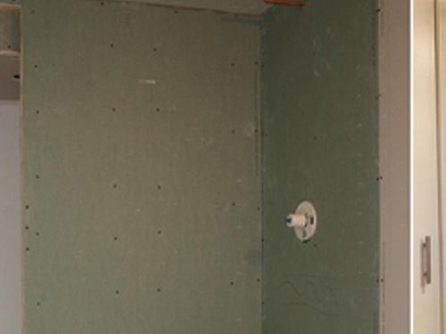 a bathroom with a green wall and a white shower head .