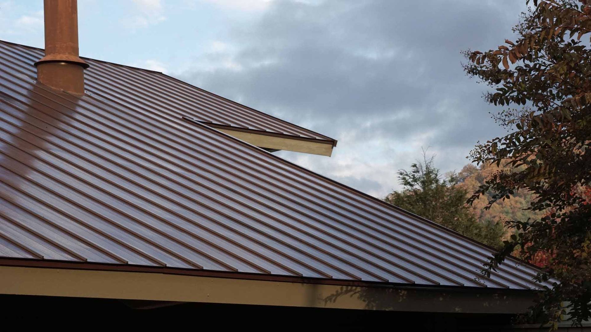 a brown metal roof with a chimney on top of it .