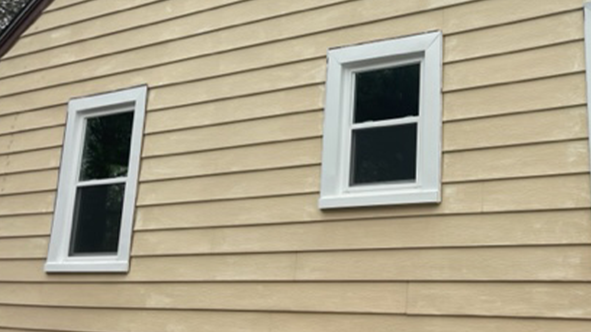 A house with two new windows on the side of it.