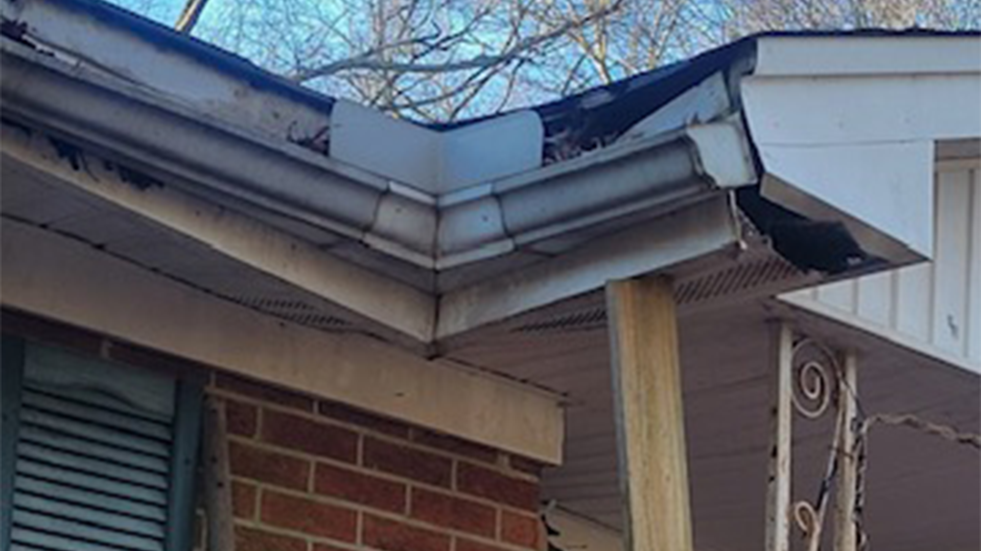 A close up of a gutter on the side of a house.