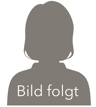 Eine Frau im blauen Kittel lächelt vor einem Mikroskop