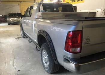 a silver truck is parked in a garage with a toolbox in the bed .