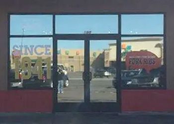 a man is standing in front of a store with a truck parked in front of it .