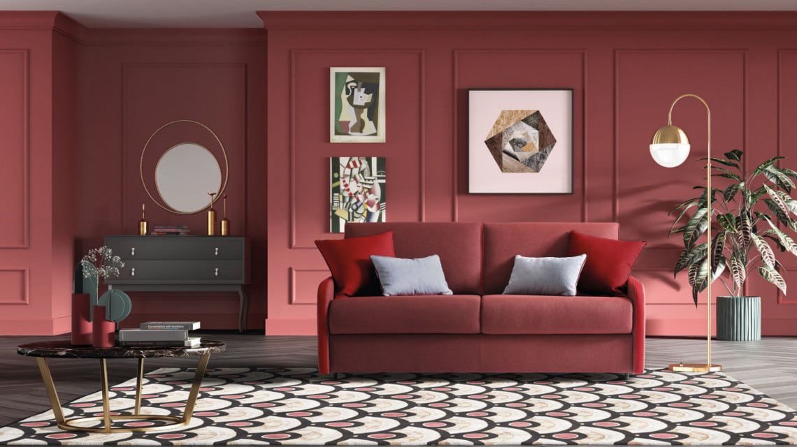Soggiorno con pareti e mobili rossi, tra cui un divano, una cassettiera e un tavolino da caffè. Opere d'arte e una lampada da terra completano l'arredamento.