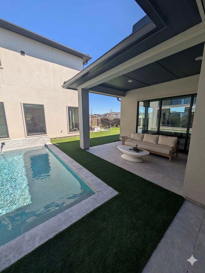Modern patio with a small pool, covered seating area, and view of the lawn and distant homes
